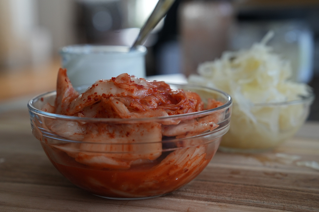 Kimchi, sauerkraut and yogurt are displayed on a kitchen table in New York on July 10, 2026. (AP Photo/Mary Conlon)