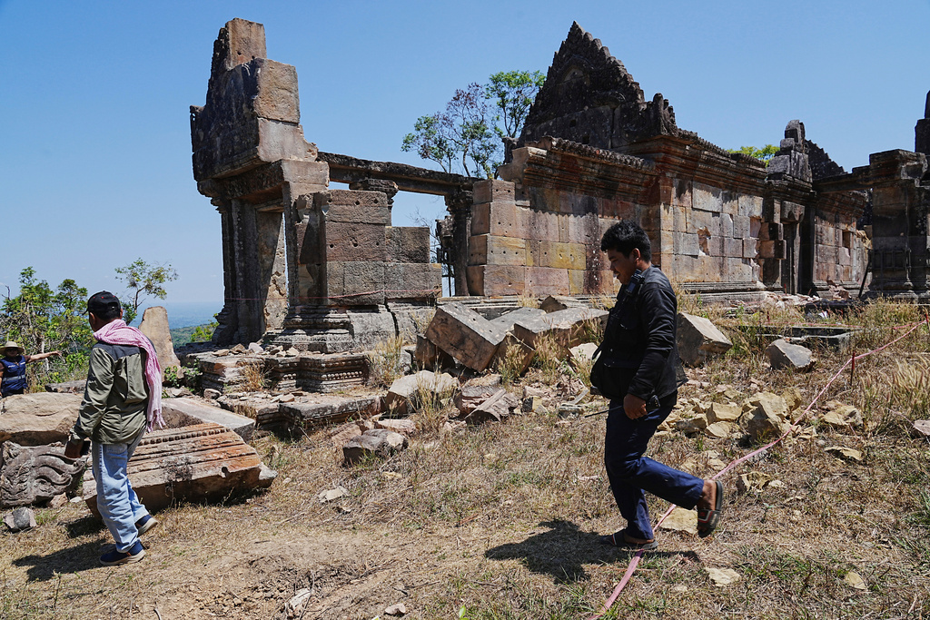 Cambodian police officers walk past a temple damaged during border clashes with Thailand, at Preah Vihear province, Cambodia, Saturday, March 14, 2026, (AP Photo/Heng Sinith)
