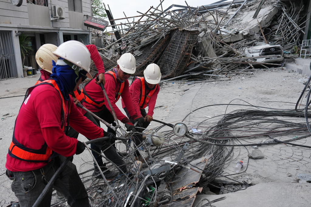 Workers cut cables during a search operation at a collapsed building where multiple people are believed to be trapped in Angeles city in Pampanga province, north of Manila, Philippines, Monday, May 25, 2026. (AP Photo/Aaron Favila)