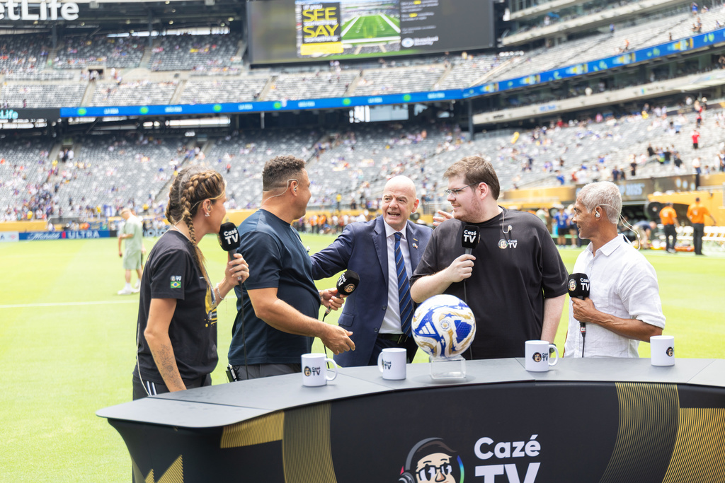 In this image provided by LiveMode, from left, Barbara Coelho, Brazil soccer star Ronaldo, FIFA President, Gianni Infantino, Casimiro Miguel and star Luisinho, greet on the set of CazéTV at the Club World Cup soccer final July 13, 2025,, in East Rutherford, N.J. (Venessa Carvalho/LiveMode via AP
