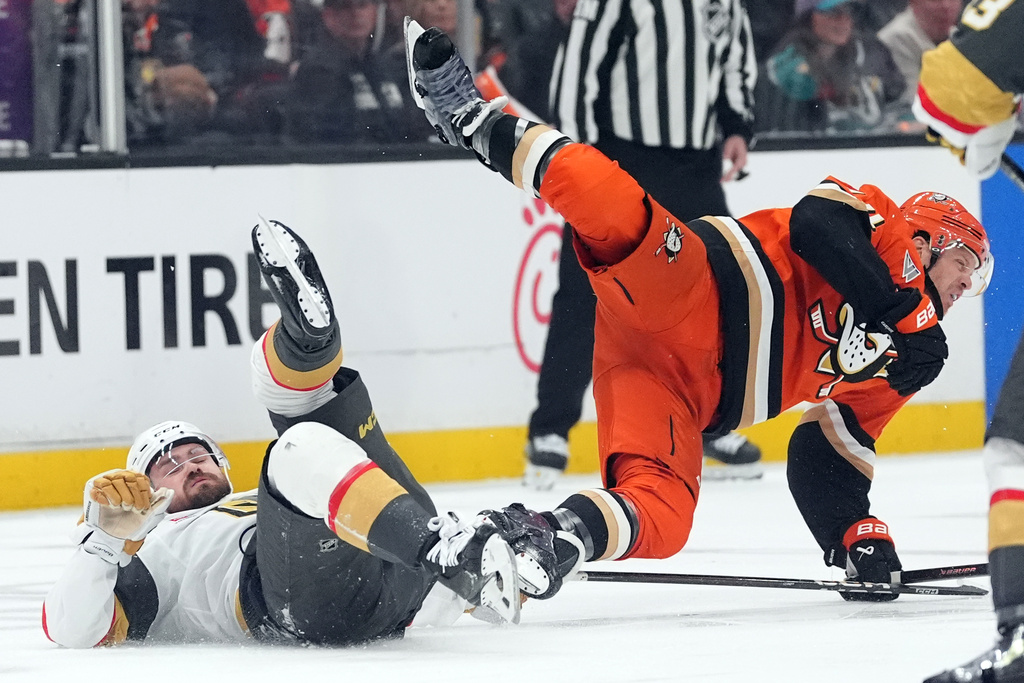 Anaheim Ducks' John Carlson (74) is tripped up by Vegas Golden Knights' Rasmus Andersson (4) during the second period of an NHL hockey game Sunday, May 10, 2026, in Anaheim, Calif. (AP Photo/Scott Strazzante)