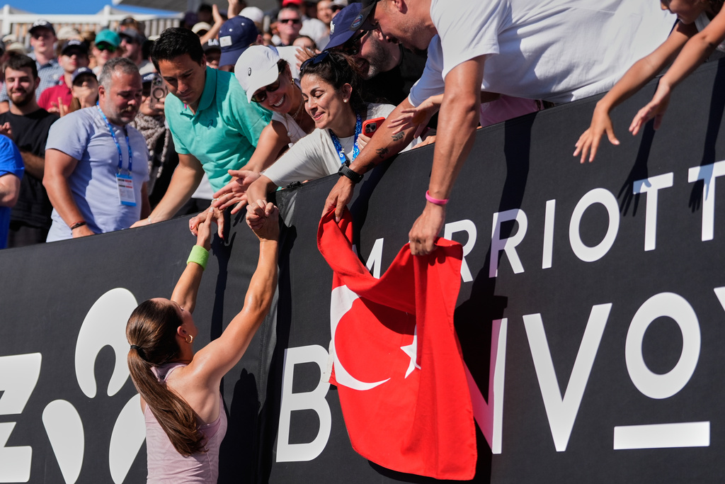 Zeynep Sonmez of Turkey celebrates with supporters after defeating Ekaterina Alexandrova of Russia following their first round match at the Australian Open tennis championship in Melbourne, Australia, Sunday, Jan. 18, 2026. (AP Photo/Asanka Brendon Ratnayake)