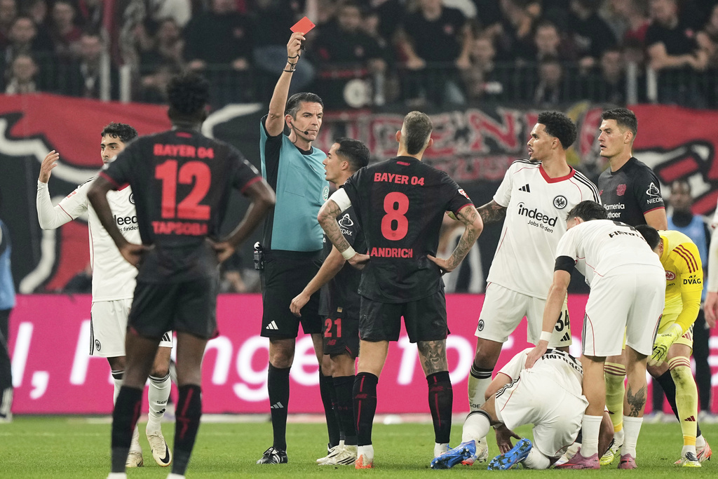 Referee Deniz Aytekin shows the red card to Leverkusen's Robert Andrich during the German Bundesliga soccer match between Bayer Leverkusen and Eintracht Frankfurt at the BayArena in Leverkusen, Germany, Friday, Sept. 12, 2025. (AP Photo/Martin Meissner)