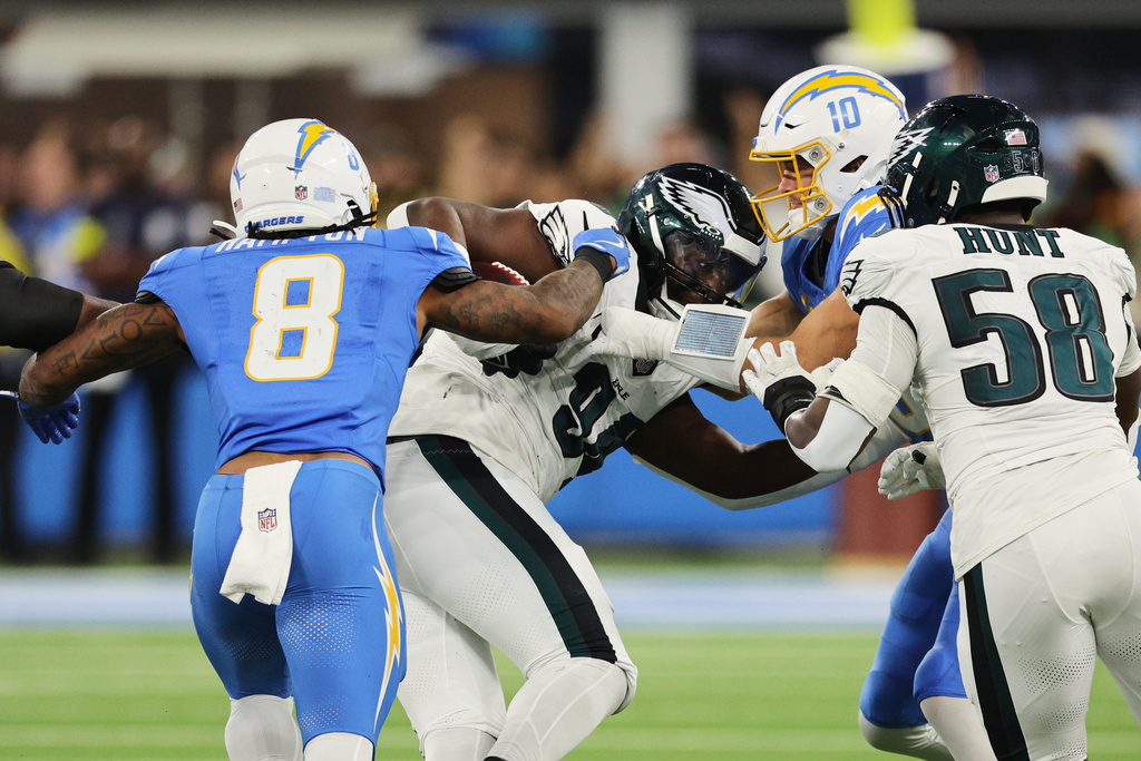 Philadelphia Eagles defensive tackle Byron Young (94) recovers a fumble by Los Angeles Chargers quarterback Justin Herbert (10) during the first half of an NFL football game Monday, Dec. 8, 2025, in Inglewood, Calif. (AP Photo/Kevork Djansezian)