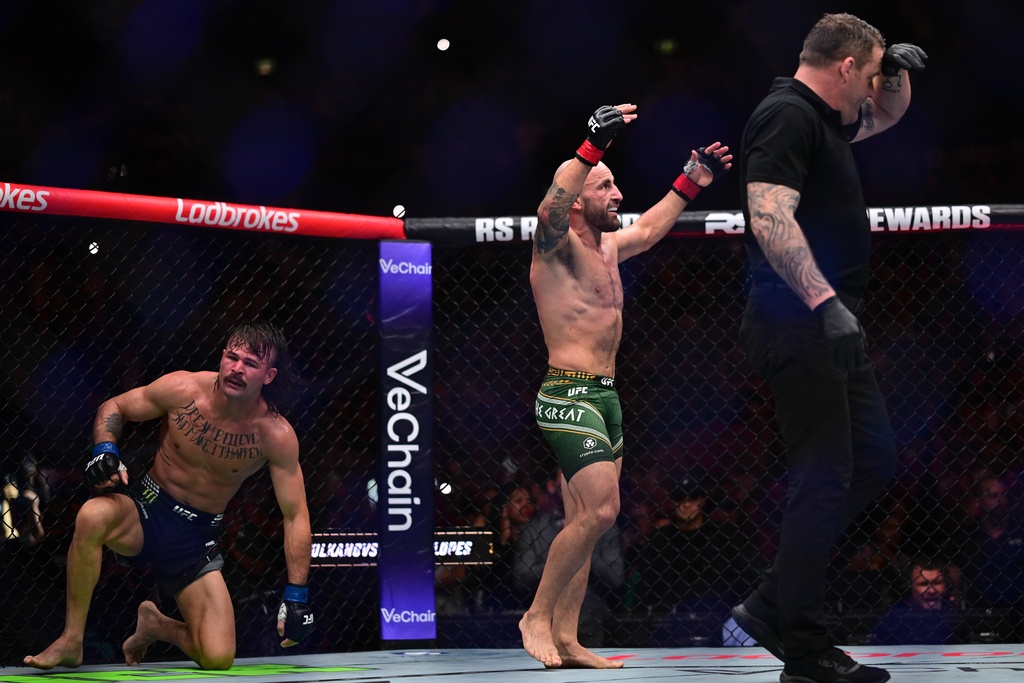 Alex Volkanovski, center, of Australia, in his featherweight title bout fights against Diego Lopes, of Brazil, during the UFC 325 event in Sydney, Sunday, Feb. 1, 2026. (Dean Lewins/AAP Image via AP)