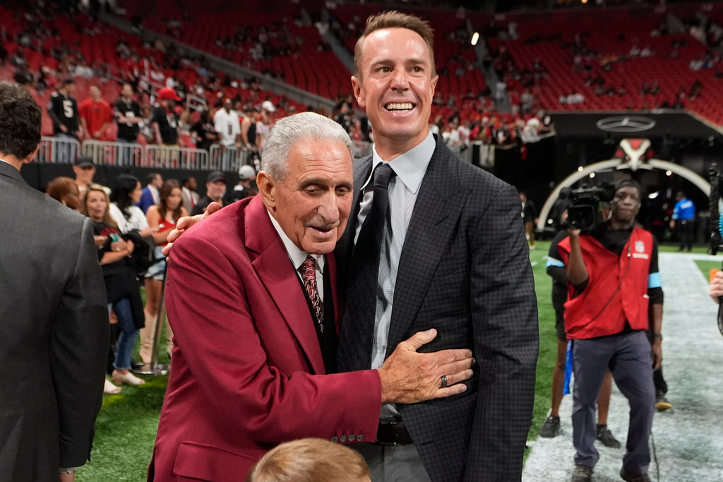 FILE - Atlanta Falcons owner Arthur Blank, left, talks to former quarterback Matt Ryan before an NFL football game against the Tampa Bay Buccaneers Oct. 3, 2024, in Atlanta. (AP Photo/John Bazemore, File)