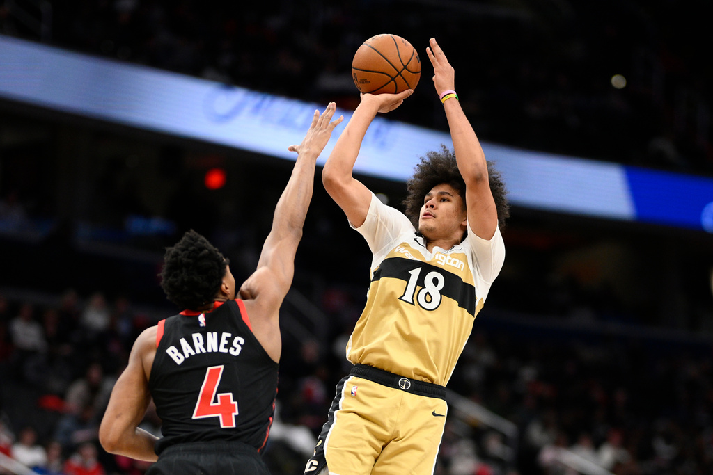 Washington Wizards forward Kyshawn George (18) goes up to shoot against Toronto Raptors forward Scottie Barnes (4) during the second half of an NBA basketball game, Friday, Dec. 26, 2025, in Washington. (AP Photo/Nick Wass)