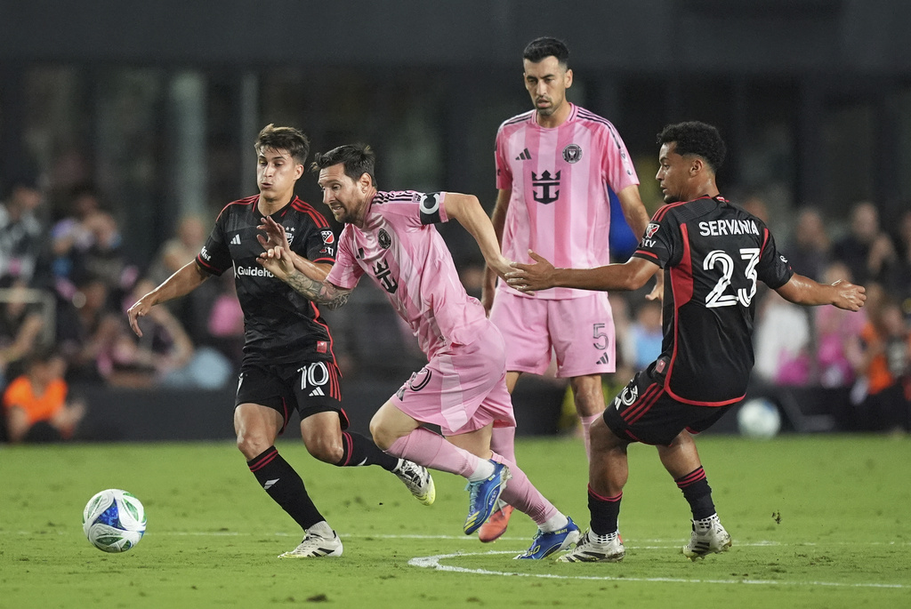 Inter Miami forward Lionel Messi, center, powers toward a ball past D.C. United midfielders Gabriel Pirani (10) and Brandon Servania (23), during the first half of an MLS soccer match, Saturday, Sept. 20, 2025, in Fort Lauderdale, Fla. (AP Photo/Rebecca Blackwell)