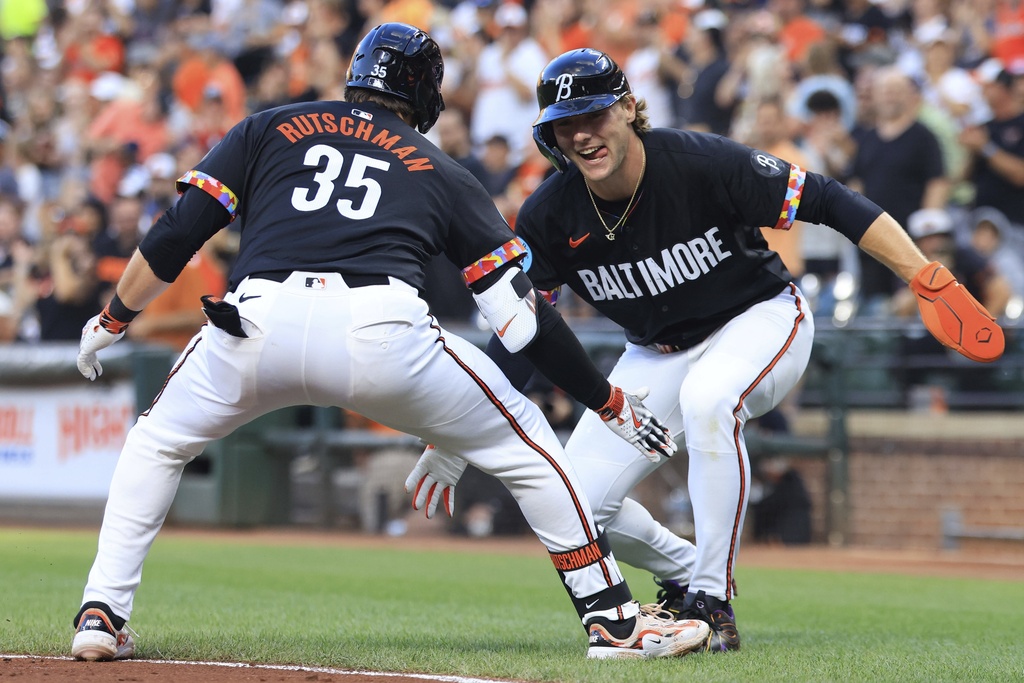 Baltimore Orioles' Adley Rutschman, left, high-fives teammate Gunnar Henderson, right, after hitting a home run during the first inning of a baseball game against the Athletics, Friday, Aug. 8, 2025, in Baltimore. (AP Photo/Alyssa Howell)