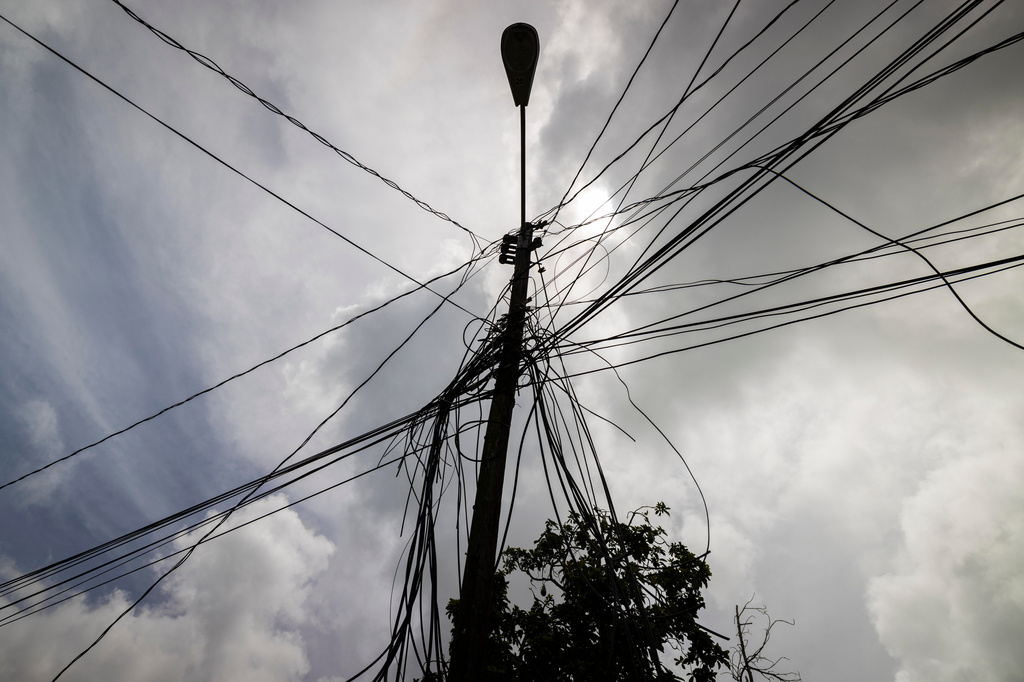 FILE - A utility pole with loose cables towers over the home of Jetsabel Osorio in Loiza, Puerto Rico, Thursday, Sept. 15, 2022. (AP Photo/Alejandro Granadillo,File)