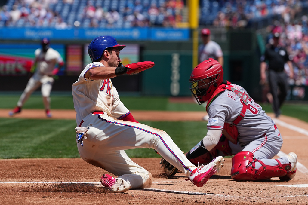 Philadelphia Phillies' Trea Turner scores past Cincinnati Reds catcher P.J. Higgins during the first inning of a baseball game, Wednesday, May 20, 2026, in Philadelphia. (AP Photo/Matt Rourke)