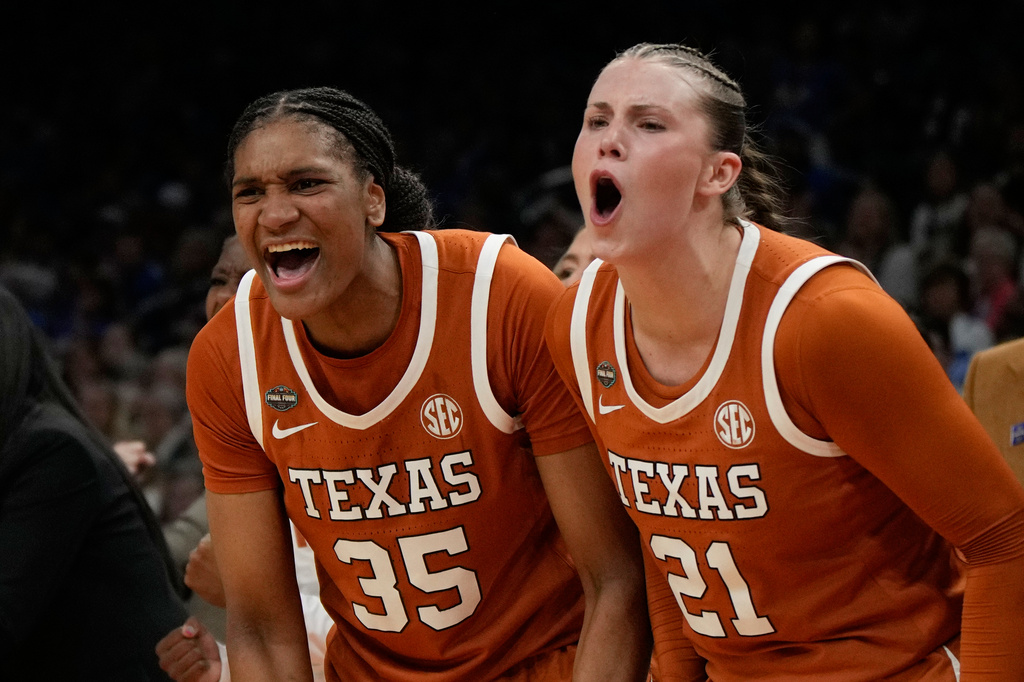 Texas forward Madison Booker (35) and Texas guard Ashton Judd (21) celebrate against UCLA during the second half of a women's NCAA college basketball tournament semifinal game at the Final Four, Friday, April 3, 2026, in Phoenix. (AP Photo/Ross D. Franklin)
