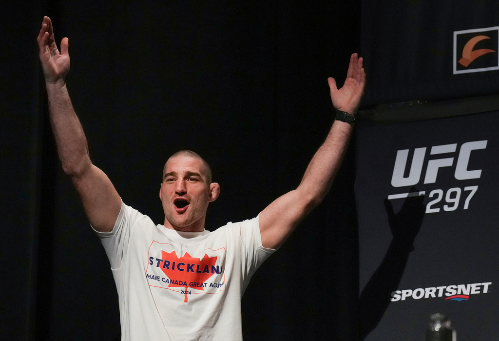 FILE - Sean Strickland, UFC middleweight champion, arrives on stage to face off with Dricus Du Plessis during a mixed martial arts news conference ahead of UFC 297 in Toronto, Thursday, Jan. 18, 2024. (Nathan Denette/The Canadian Press via AP, FIle)