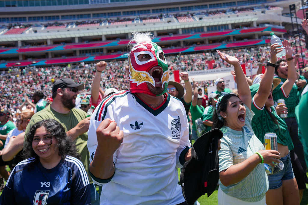 Fans celebrate a goal by Mexico while watching a live broadcast of the World Cup soccer match between Mexico and South Africa at the Los Angeles Memorial Coliseum in Los Angeles, Thursday, June 11, 2026. (AP Photo/Jae C. Hong)