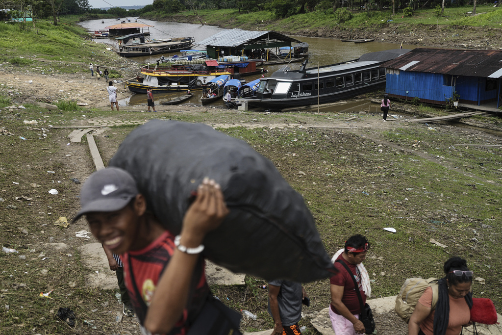Residents of Santa Rosa, a Peruvian island on the Amazon River, load goods in Leticia, Colombia, Sunday, Aug. 17, 2025. (AP Photo/Ivan Valencia)