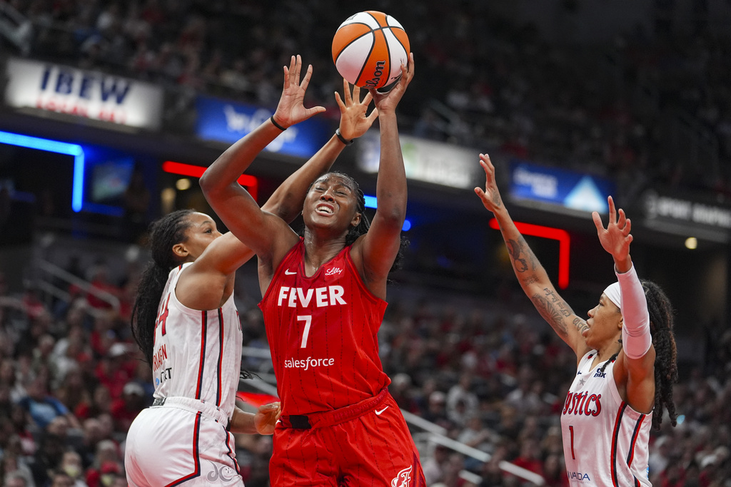 Indiana Fever forward Aliyah Boston (7) shoots between Washington Mystics forward Kiki Iriafen (44) and Washington Mystics guard Sug Sutton (1) in the first half of a WNBA basketball game in Indianapolis, Friday, Aug. 15, 2025. (AP Photo/Michael Conroy)