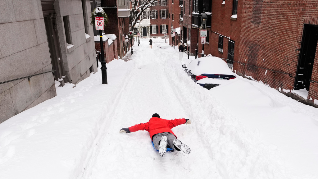 Ian Flood sleds down a street in his Beacon Hill neighborhood following a winter storm that dump more than a foot of snow across the region, Monday, Jan. 26, 2026, in Boston. (AP Photo/Charles Krupa)