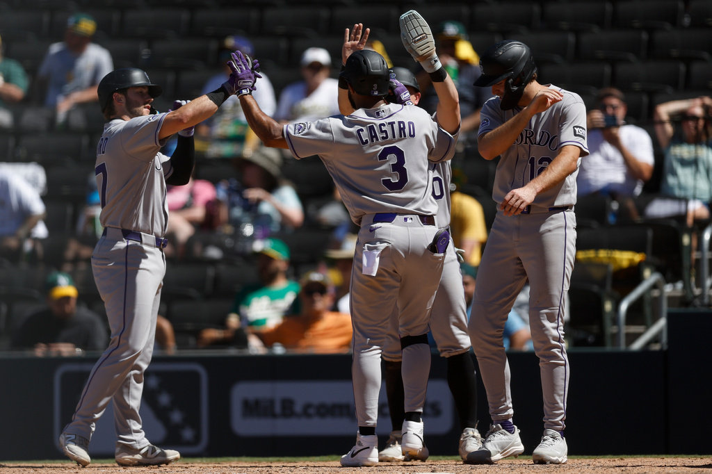 Colorado Rockies' Willi Castro (3), center, is greeted by teammates after hitting a grand slam during the eighth inning of a baseball game against the Athletics, Sunday, June 14, 2026, in Las Vegas. (AP Photo/Caroline Brehman)