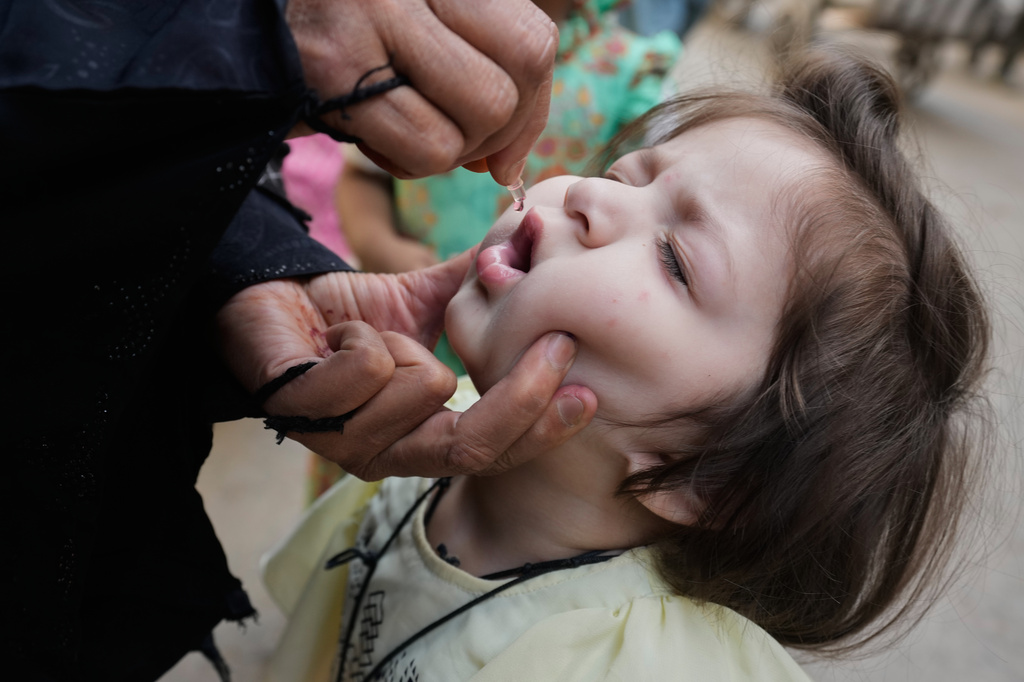 A health worker administers a polio vaccine to a child in Lahore, in Lahore, Pakistan, Monday, April 13, 2026. (AP Photo/K.M. Chaudary)
