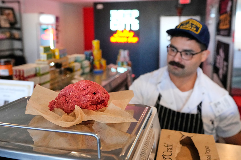 Nate Abeyta, owner and founder of Deep Cuts butcher shop prepares an order of ground meat for a customer, Tuesday, Oct. 21, 2025, in Dallas. (AP Photo/Tony Gutierrez)