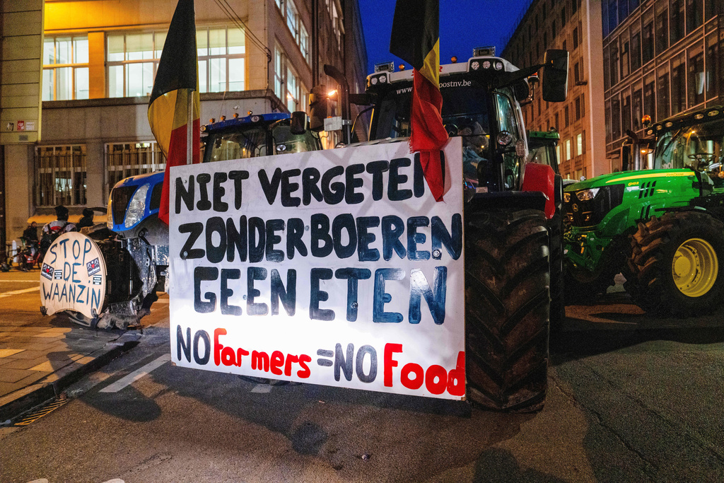 A farmer drives a tractor with a sign that reads in Dutch 'Don't forget, without farmers there's no food' during a demonstration outside a gathering of European leaders at the EU Summit in Brussels, Thursday, Dec. 18, 2025. (AP Photo/Marius Burgelman)