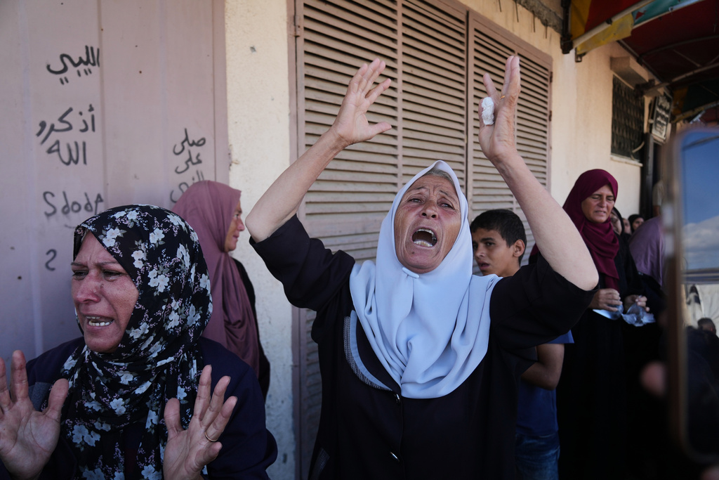 Palestinians mourn during the funeral of their relatives who were killed in an Israeli airstrike on Deir al-Balah, central Gaza Strip, Wednesday, Oct. 1, 2025. (AP Photo/Abdel Kareem Hana)