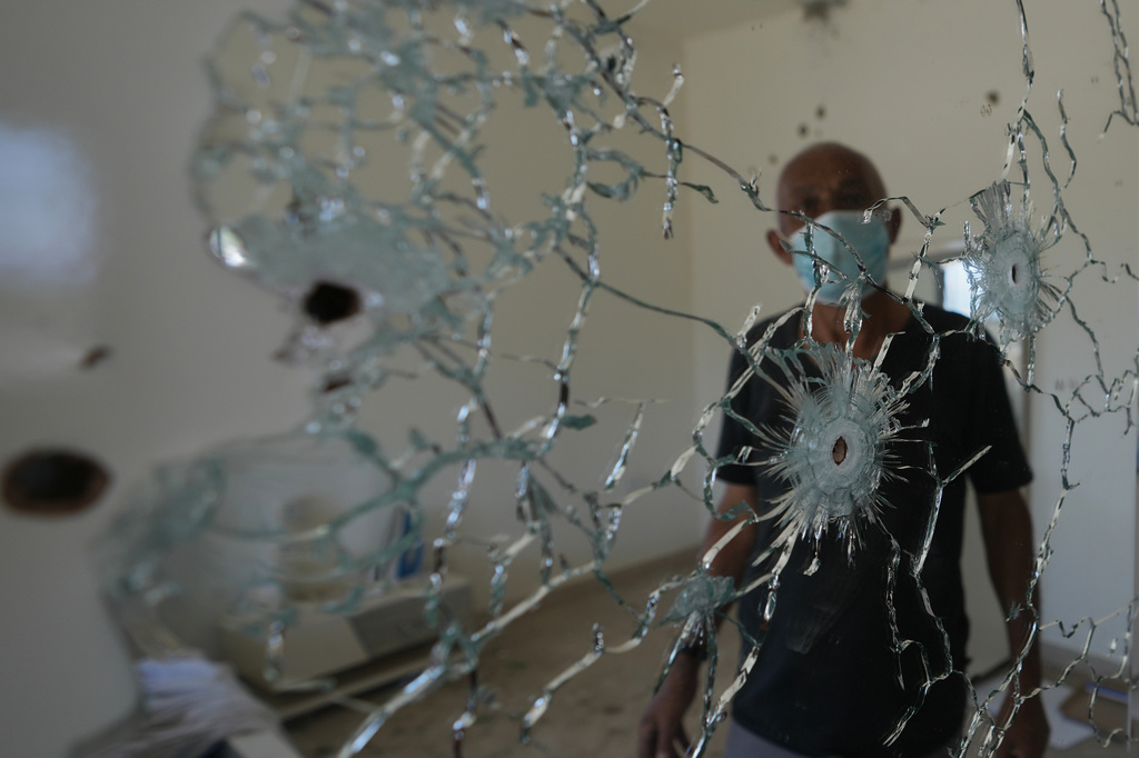 A resident stands behind a mirror riddled with bullet holes inside his home following an Israeli military operation in Zawtar al-Gharbieh, Lebanon, Tuesday, July 28, 2026. (AP Photo/Hassan Ammar)