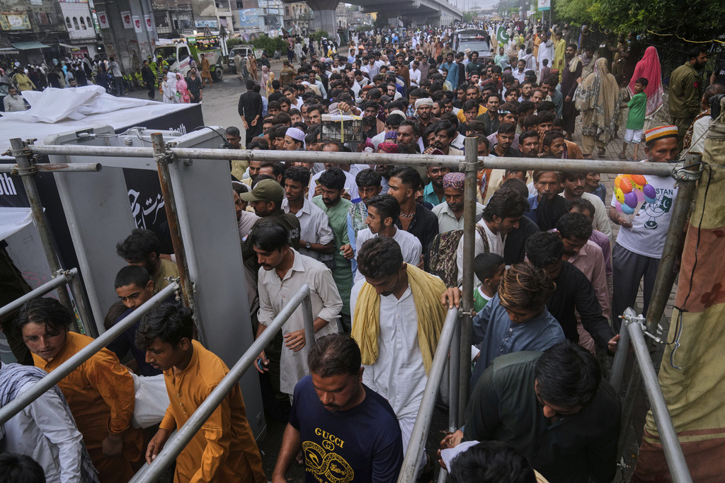 Devotees pass walk through gate at a checkpoint as they arrive to attend celebrations of the three-day annual festival or 'Urs' of mystic and scholar Hazrat Ali Hajveri, popularly known as Data Ganj Bakhsh at his shrine, in Lahore, Pakistan, Thursday, Aug. 14, 2025. (AP Photo/K.M. Chaudary)
