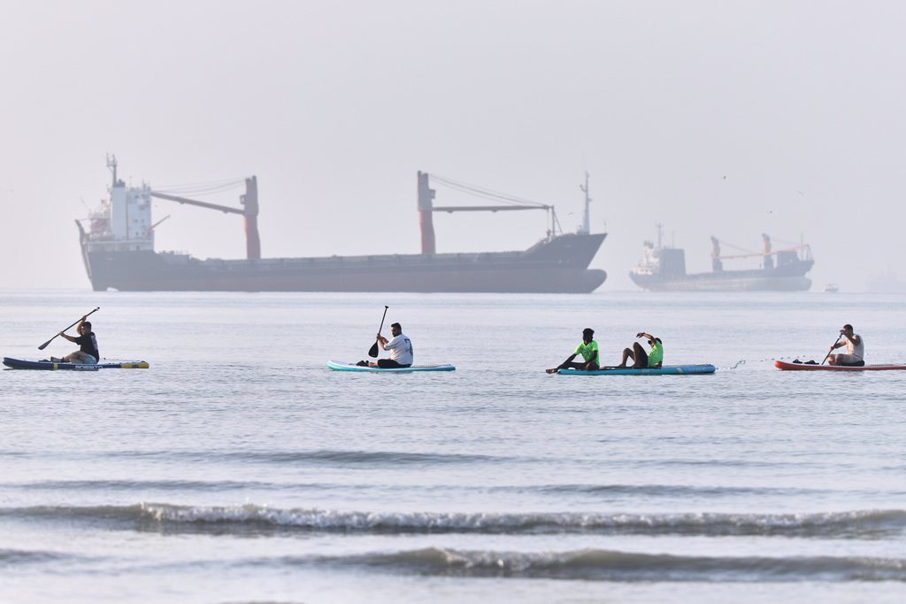 People paddle along the shoreline as cargo ships are anchored in the Strait of Hormuz off Bandar Abbas, Iran, Monday, June 1, 2026. (Amirhosein Khorgooi/ISNA via AP)