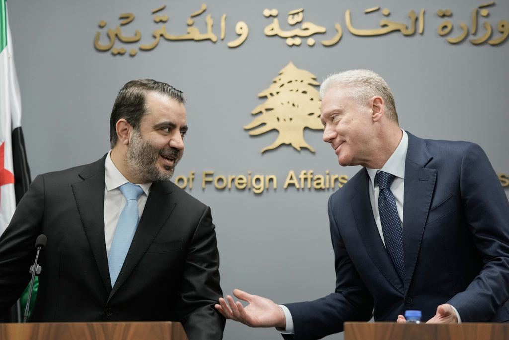 Syrian Foreign Minister Asaad al-Shibani, left, speaks with Lebanese Foreign Minister Youssef Rajji, right, before a briefing for journalists following their meeting in Beirut, Lebanon, Friday, Oct. 10, 2025. (AP Photo/Hassan Ammar)