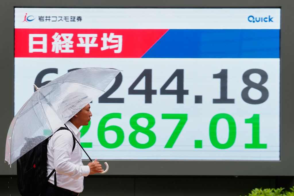 A person walks in front of an electronic stock board showing Japan's Nikkei index at a securities firm Tuesday, July 28, 2026, in Tokyo. (AP Photo/Eugene Hoshiko)