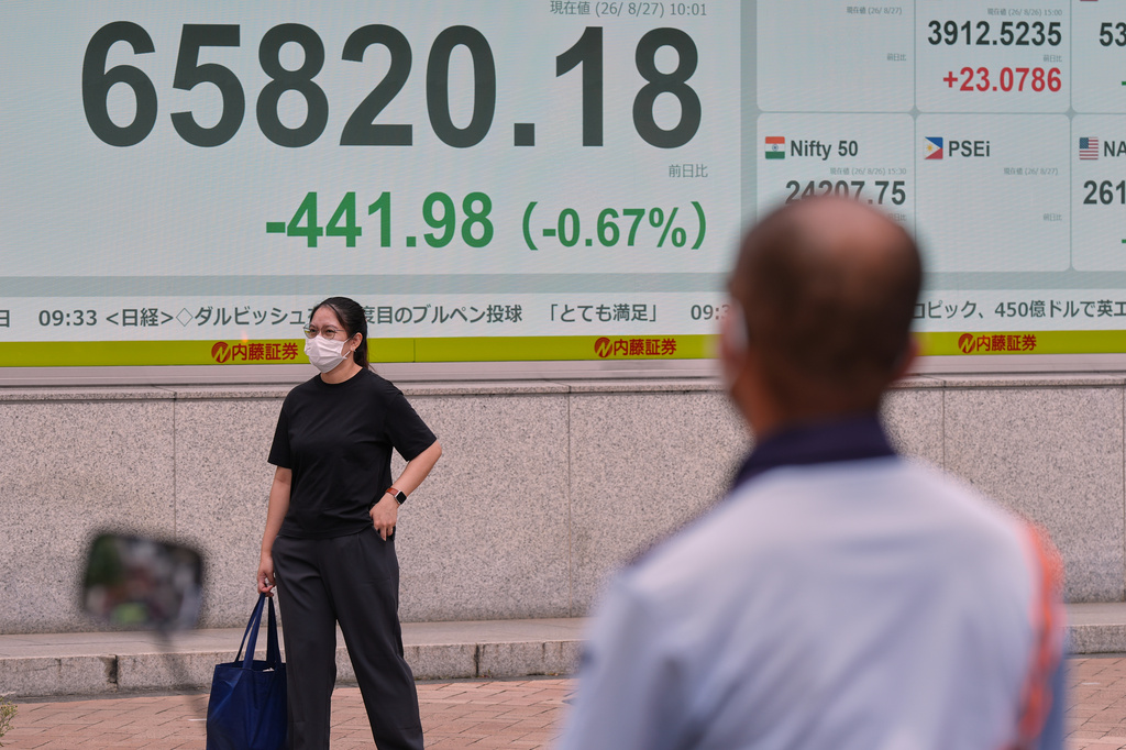 People stand near an electronic stock board showing Japan's Nikkei index at a securities firm Thursday, Aug. 27, 2026, in Tokyo. (AP Photo/Eugene Hoshiko)