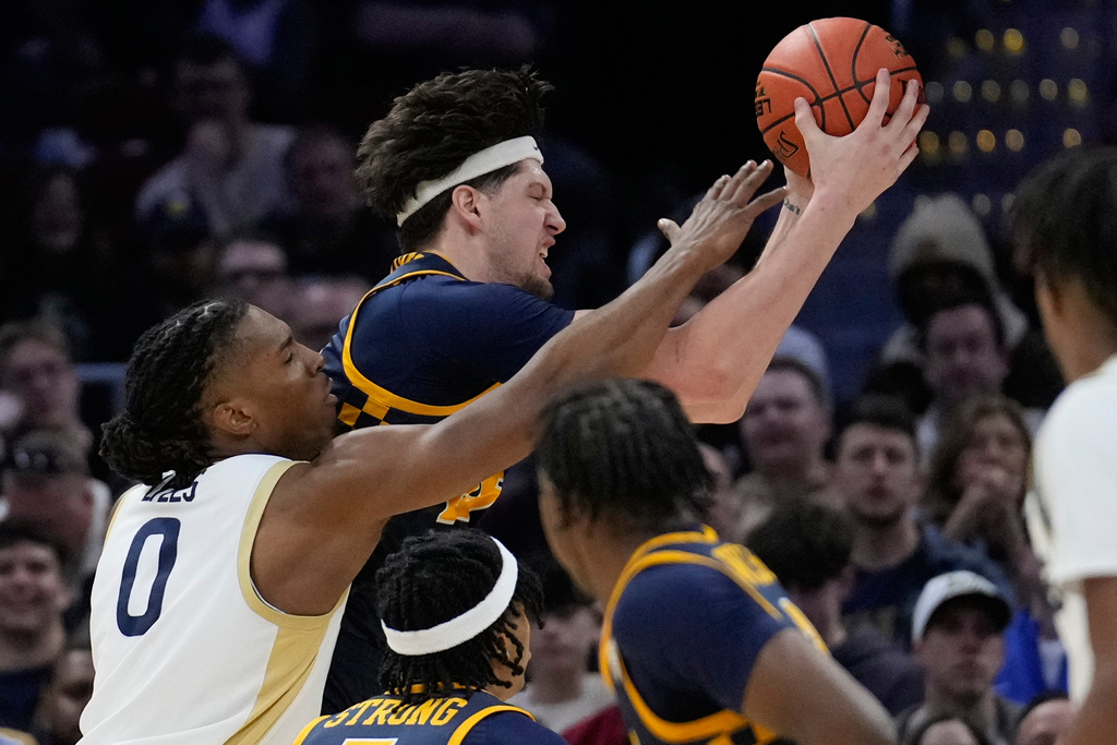 Akron forward Amani Lyles (0) reaches for a rebound with Toledo center Austin Parks, right, in the first half of an NCAA college basketball game in the championship of the Mid-American Conference tournament, Saturday, March 14, 2026, in Cleveland. (AP Photo/Sue Ogrocki)
