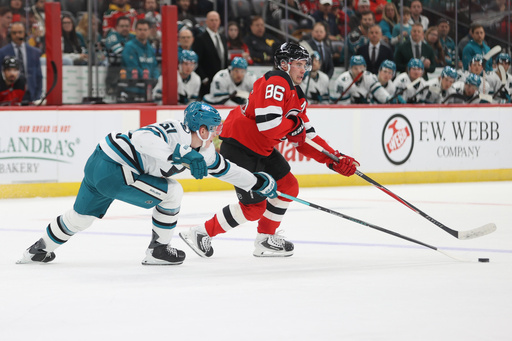New Jersey Devils' Jack Hughes, right, competes for the puck with San Jose Sharks' Collin Graf, left, during the second period of an NHL hockey game Friday, Oct. 24, 2025, in Newark, N.J. (AP Photo/Pamela Smith) New Jersey Devils' Jack Hughes, right, competes for the puck with San Jose Sharks' Collin Graf, left, during the second period of an NHL hockey game Friday, Oct. 24, 2025, in Newark, N.J. (AP Photo/Pamela Smith)