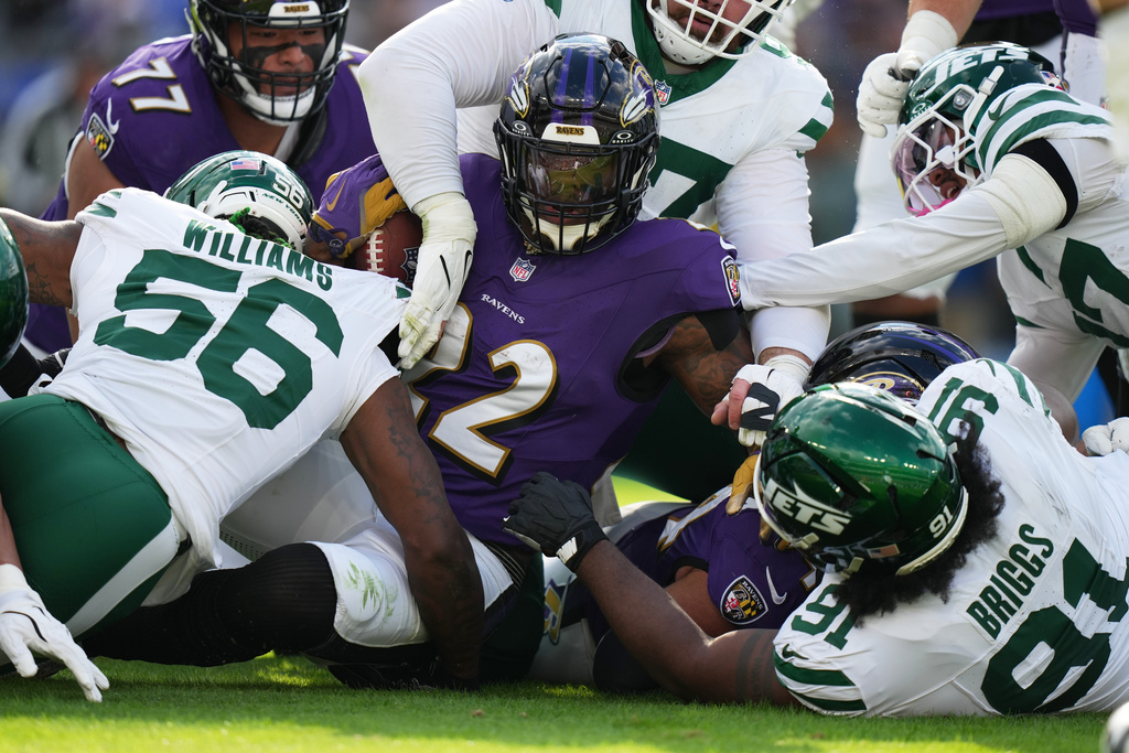 Baltimore Ravens running back Derrick Henry (22) is defended by New York Jets linebacker Quincy Williams (56) and defensive tackle Jowon Briggs (91) during the first half of an NFL football game, Sunday, Nov. 23, 2025, in Baltimore. (AP Photo/Stephanie Scarbrough)