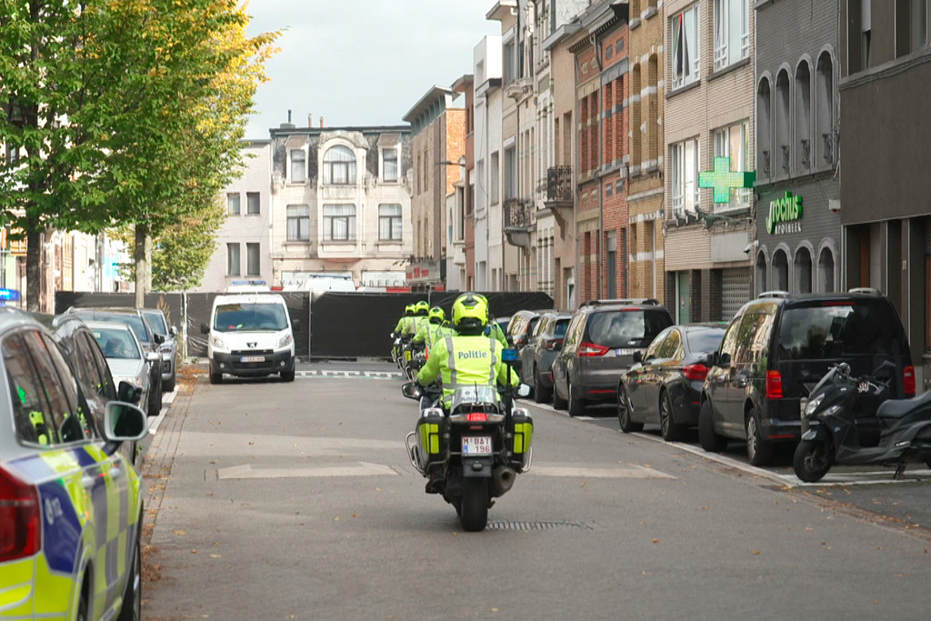 In this image taken from video provided by VTM, police on motorcycles drive toward a black police cordon set up in a street during an investigation in Antwerp, Belgium, Thursday, Oct. 9, 2025. (VTM via AP)