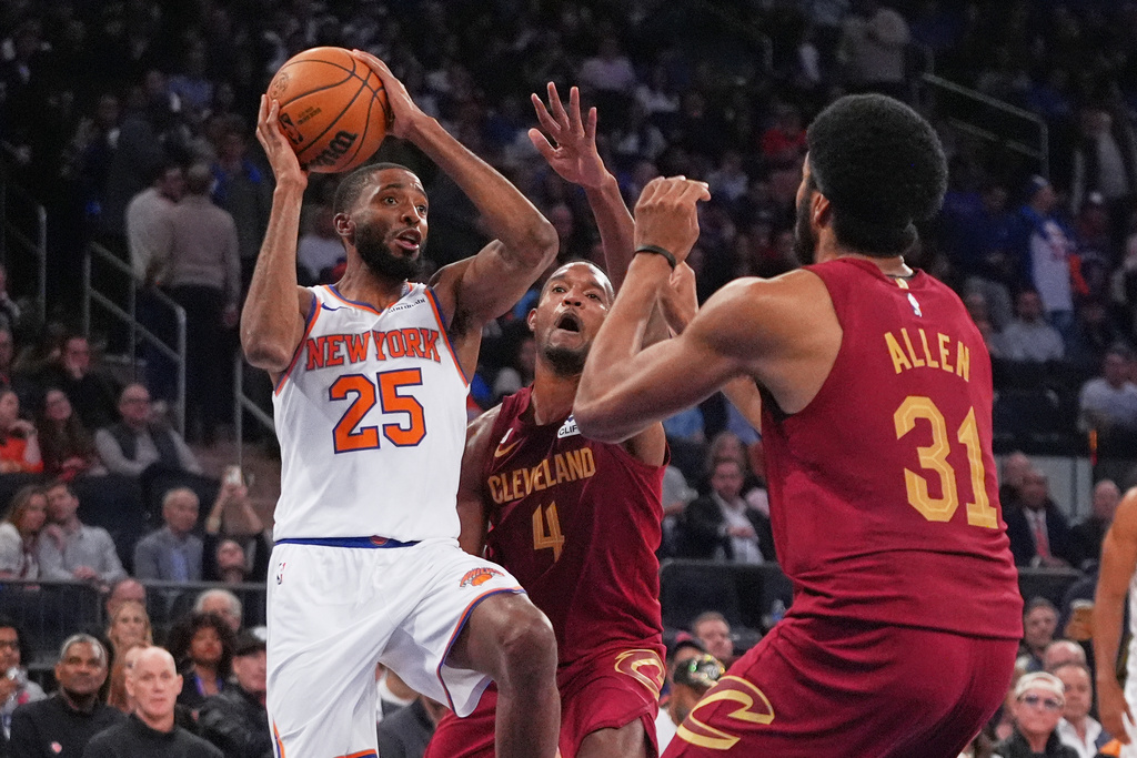 New York Knicks' Mikal Bridges (25) drives past Cleveland Cavaliers' Evan Mobley (4) and Jarrett Allen (31) during the second half of an NBA basketball game Wednesday, Oct. 22, 2025, at Madison Square Garden in New York. (AP Photo/Frank Franklin II)