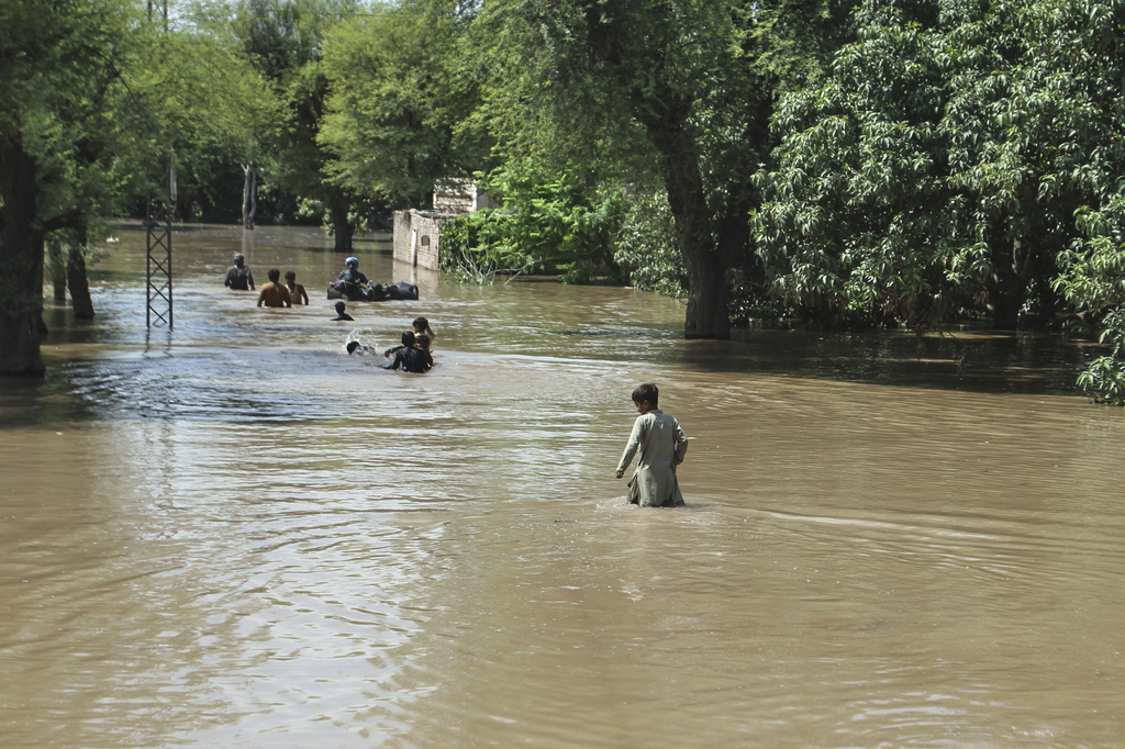 Villagers wade through a flooded area following heavy rains and raising water in rivers, in Muzaffargarh, Pakistan, Thursday, Sept. 4, 2025. (AP Photo/Asim Tanveer)