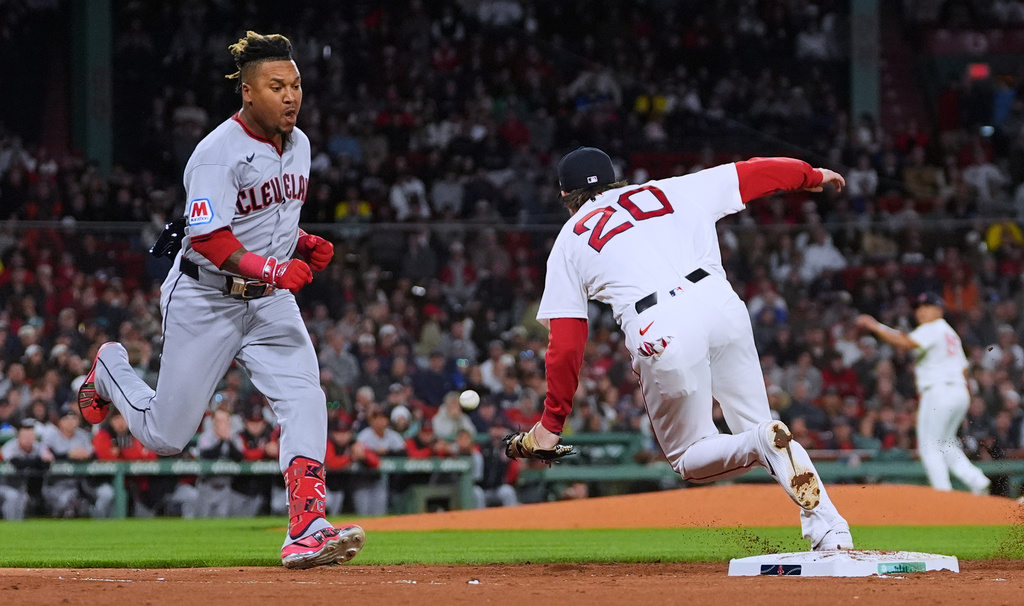 Cleveland Guardians' José Ramírez, left, dashes down the first base line as Boston Red Sox's Nick Sogard (20) steps away from the base on a single during the third inning of a baseball game, Thursday, Sept. 24, 2026, in Boston. (AP Photo/Charles Krupa)