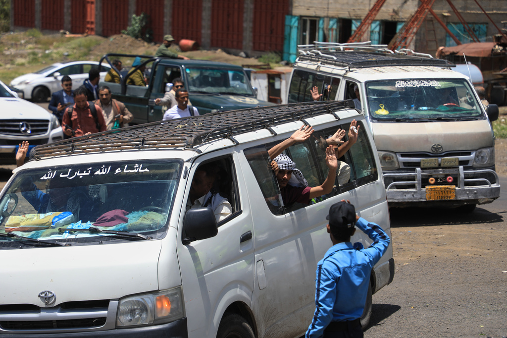 Houthi prisoners wave from vehicles as they travel through the Bani Matar district on their way to Sanaa, Yemen, Saturday, Sept. 12, 2026, after being freed in Mokha following the Houthi takeover of the southern Red Sea port city. (AP Photo/STR)