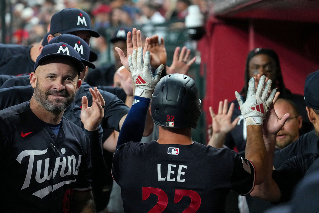Minnesota Twins' Brooks Lee, center, gets high fives from teammates after scoring a run against the Arizona Diamondbacks during the fourth inning of a baseball game Saturday, June 20, 2026, in Phoenix. (AP Photo/Darryl Webb)