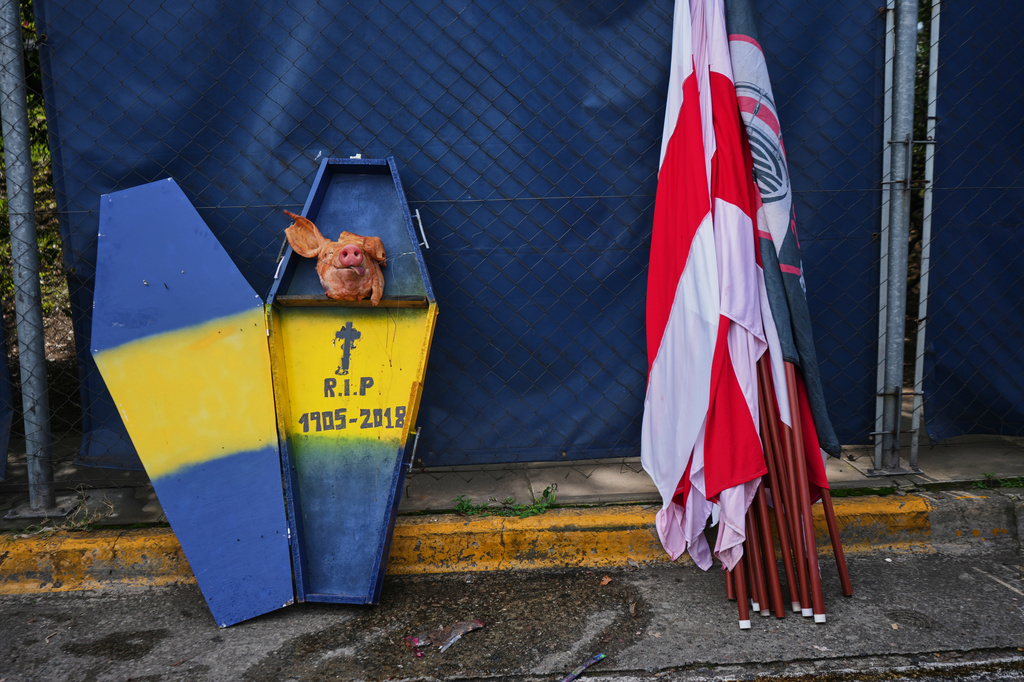 A cardboard coffin decorated with Boca Juniors' colors sits next to River Plate flags next to a highway prior to an Argentine league soccer match in Buenos Aires, Argentina, Sunday, April 19, 2026. (AP Photo/Rodrigo Abd)