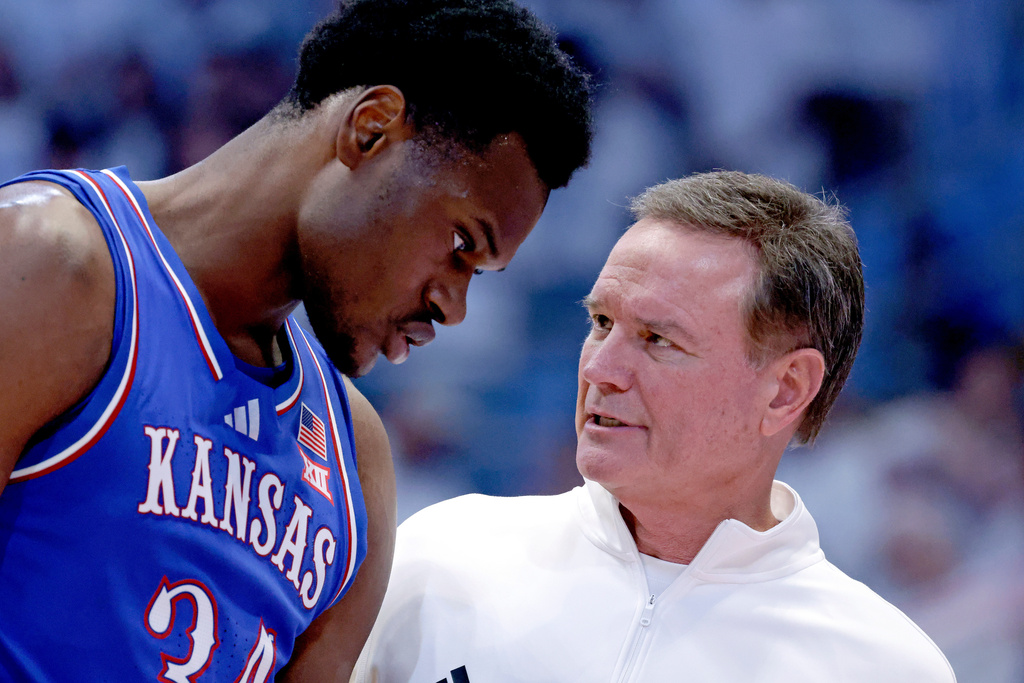 Kansas center Paul Mbiya (34) talks with head coach Bill Self during the second half of an NCAA college basketball game against North Carolina, Friday, Nov. 7, 2025, in Chapel Hill, N.C. (AP Photo/Chris Seward)