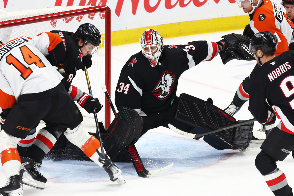 Buffalo Sabres goaltender Alex Lyon (34) slides across the crease to make a save during the third period of an NHL hockey game against the Philadelphia Flyers, Thursday, Dec. 18, 2025, in Buffalo, N.Y. (AP Photo/Jeffrey T. Barnes)