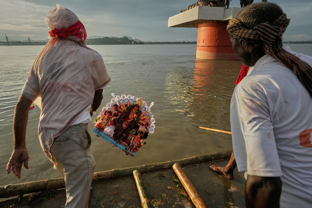 Municipal workers carry an idol of Hindu goddess Durga to immerse in river Brahmaputra in Guwahati, Thursday, Oct. 2, 2025. (AP Photo/Anupam Nath)