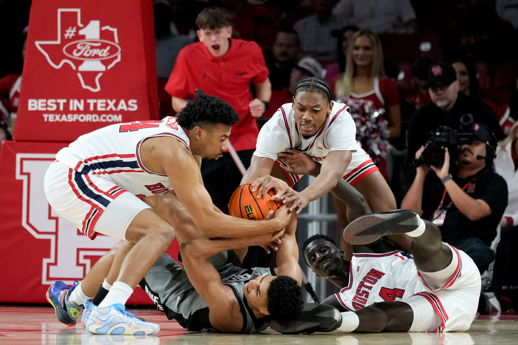 CORRECTS ID AT RIGHT TO FORWARD KALIFA SAKHO, NOT GUARD KINGSTON FLEMINGS - Colorado guard Jalin Holland, bottom, Houston forward Chase McCarty, left, guard Mercy Miller, top, and forward Kalifa Sakho, right, battle for a loose ball during the first half of an NCAA college basketball game Saturday, Feb. 28, 2026, in Houston. (AP Photo/Eric Christian Smith)