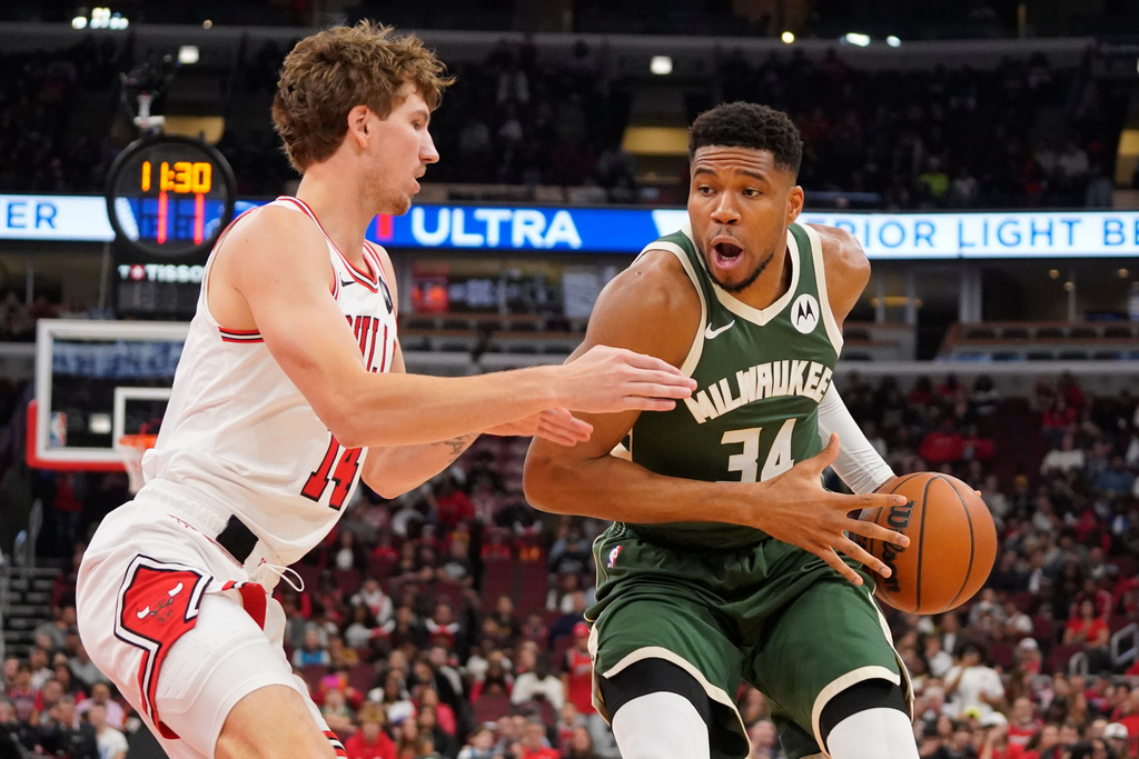 Chicago Bulls forward Matas Buzelis, left, defends against Milwaukee Bucks forward Giannis Antetokounmpo, right, during the first half of a preseason NBA basketball game Sunday, Oct. 12, 2025, in Chicago. (AP Photo/David Banks)