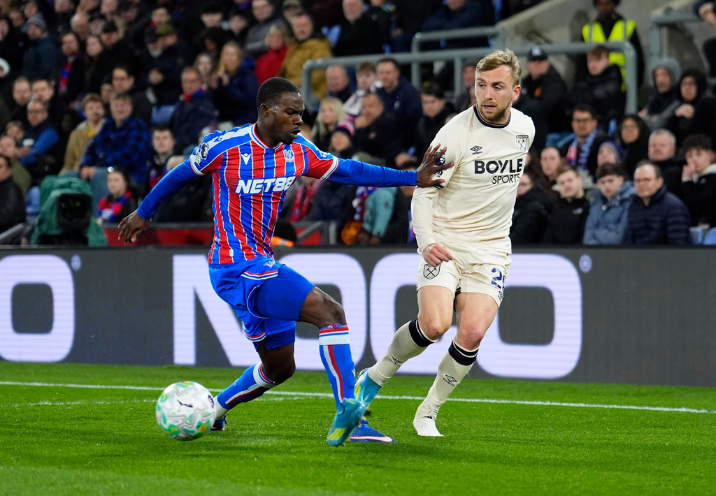 West Ham United's Jarrod Bowen, right, and Crystal Palace's Tyrick Mitchell, left, challenge for the ball during the English Premier League soccer match between Crystal Palace and West Ham United in London, England, Monday, April 20, 2026. (Jordan Pettitt/PA via AP)