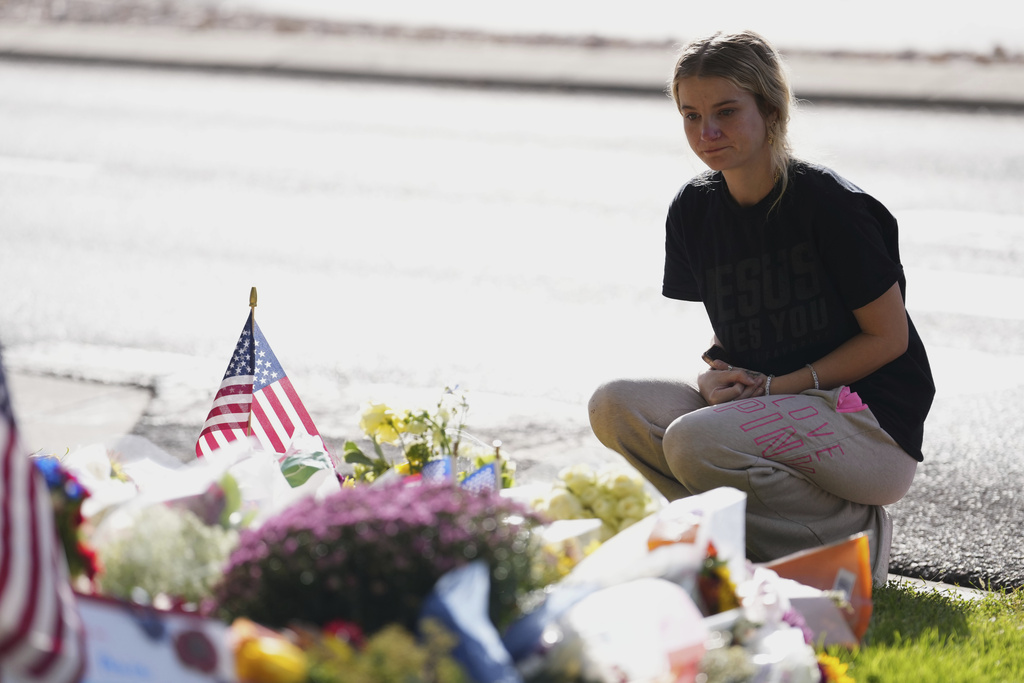 Meagan Bradley kneels at a memorial is set up for Charlie Kirk at Utah Valley University in Orem, Utah, Friday, Sept. 12, 2025. (AP Photo/Lindsey Wasson)