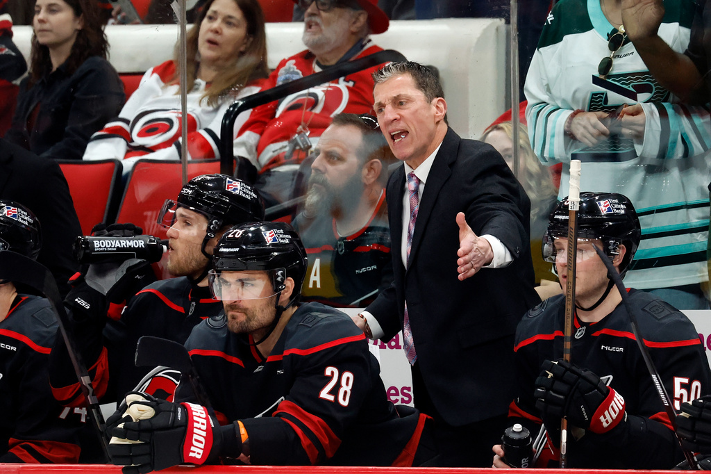 Carolina Hurricanes' Rod Brind'Amour, center, protests a call with officials during the second period of an NHL hockey game against the New York Islanders in Raleigh, N.C., Saturday, April 4, 2026. (AP Photo/Karl DeBlaker)
